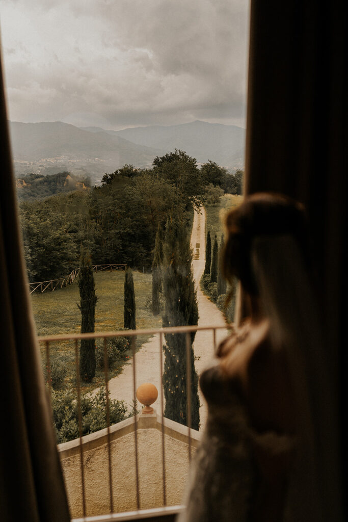 Die Braut genießt ihren Moment kurz vor dem First Look und sucht den Blick schaut in die Ferne in die romantische Landschaft in der Toskana
