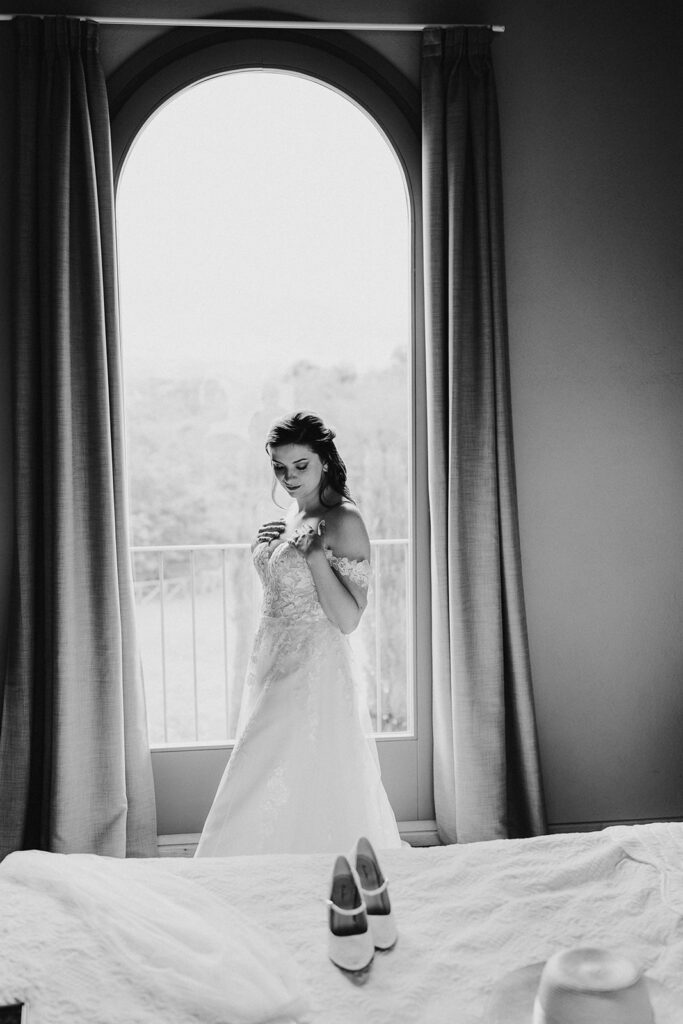 Die Braut mit ihrem Brautkleid in ihrem Zimmer kurz vor der Trauung und Hochzeit in der Toskana