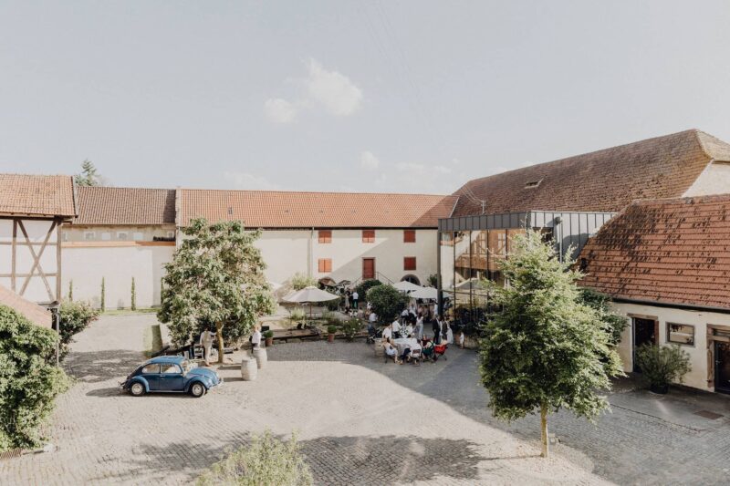 Blick auf den Innenhof des Hofguts Heidesheim mit seinen historischen Gebäuden und einem tollen Setup für den Sektempfang.