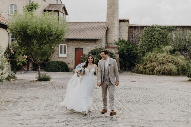 Sarah und Jakob im Innenhof des Hofguts Heidesheim mit den historischen Gebäuden im Hintergrund